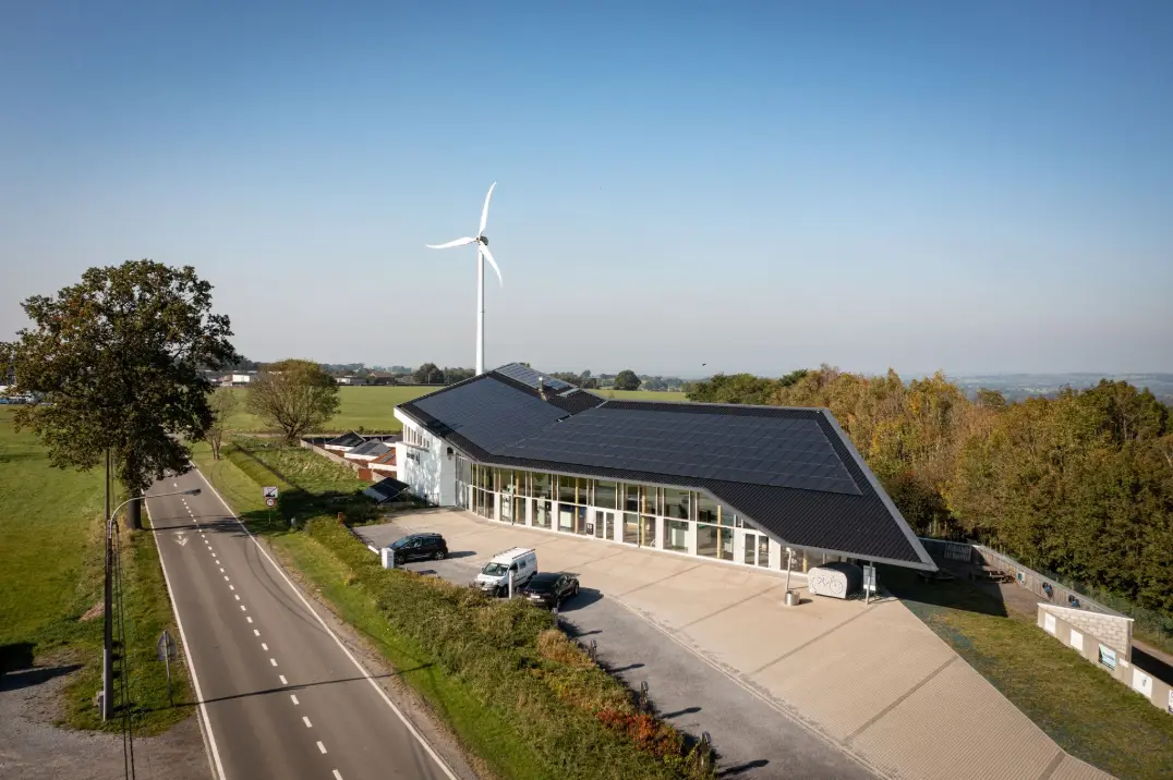 Bâtiment équipé de panneaux photovoltaïques avec une éolienne de production d’énergie locale